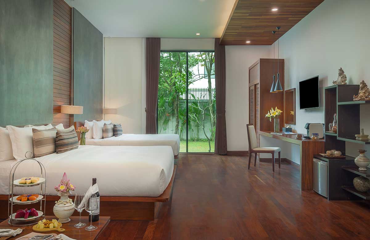 Spacious Family Suite at Shintana Saya Residence Siem Reap featuring twin beds, a workspace, and a private garden view.