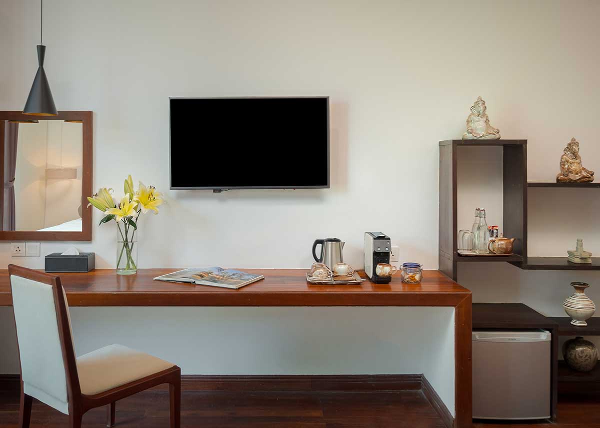 Modern desk and in-room amenities in the Family Suite at Shintana Saya Residence including a TV, coffee maker, and mini-fridge.