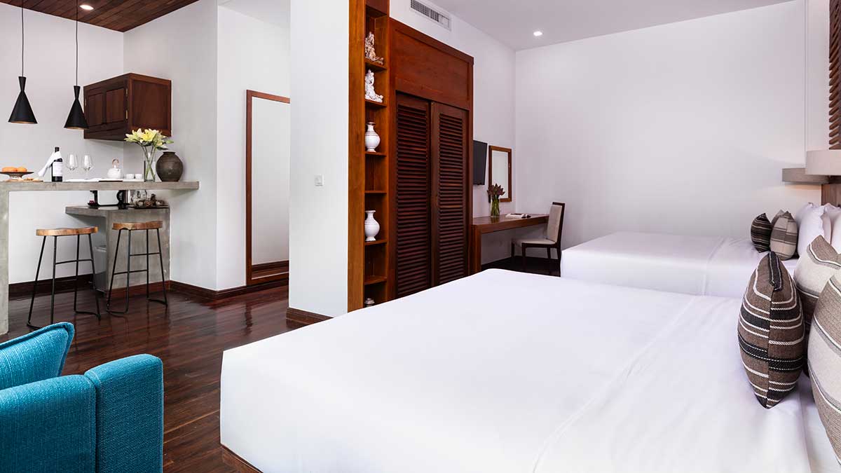 Family Suite bedroom at Shintana Saya Residence Siem Reap featuring twin beds and a private kitchen bar.