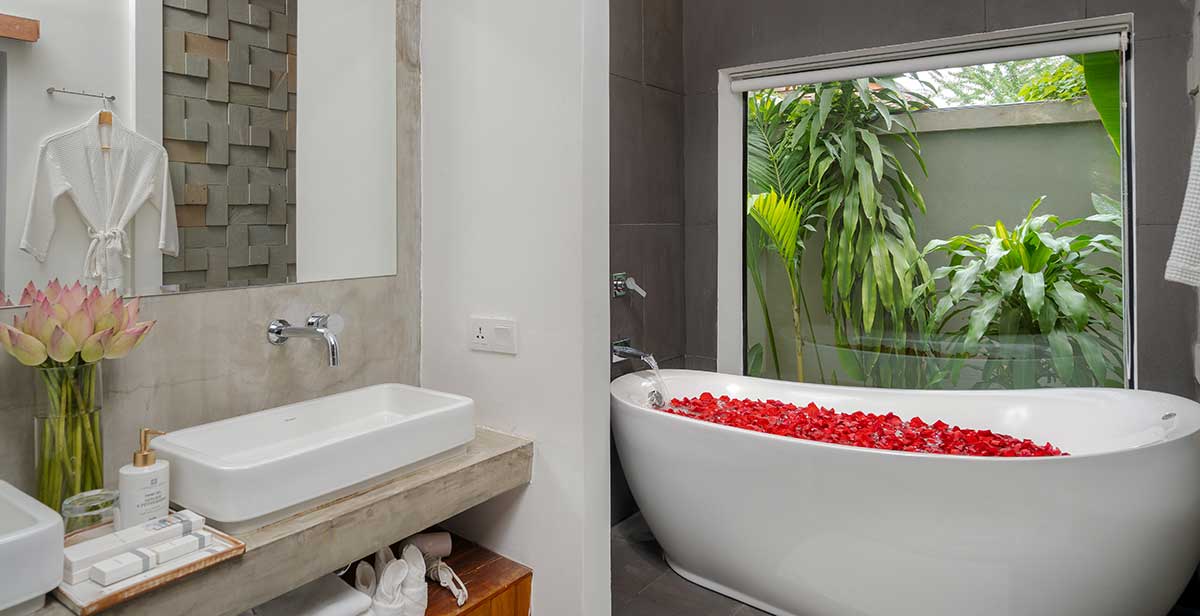 Luxury bathtub with rose petals and garden view in the Family Suite at Shintana Saya Residence Siem Reap.