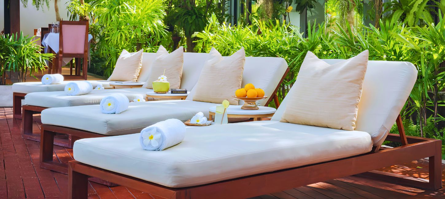 Luxury poolside sun loungers with cushions and rolled towels at Shintana Saya Residence.