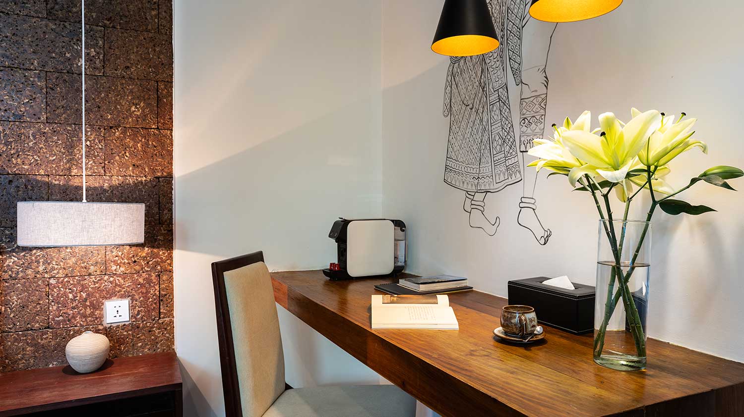 Interior design of a Premium Room at Shintana Saya Residence with a desk and floral arrangement.