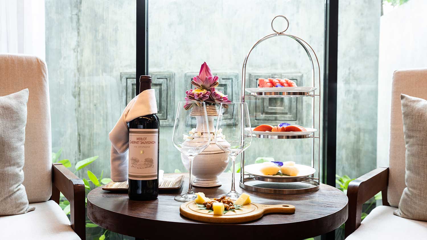 In-room welcome amenities featuring red wine, fresh fruit, and snacks.