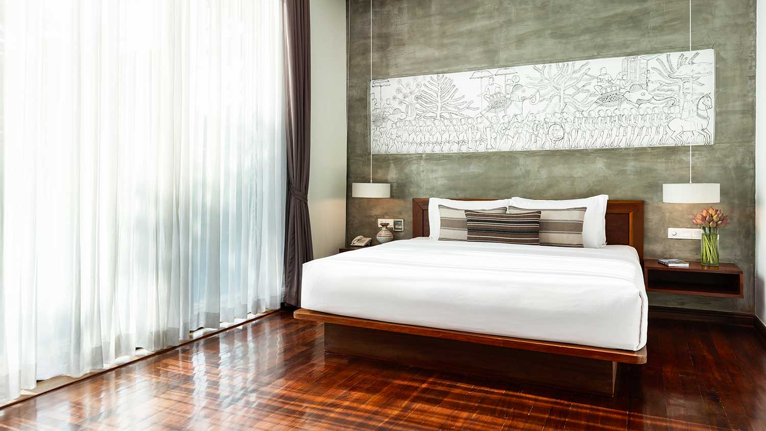 Spacious Royal Suite bedroom with a king-sized bed and traditional Khmer wall art.