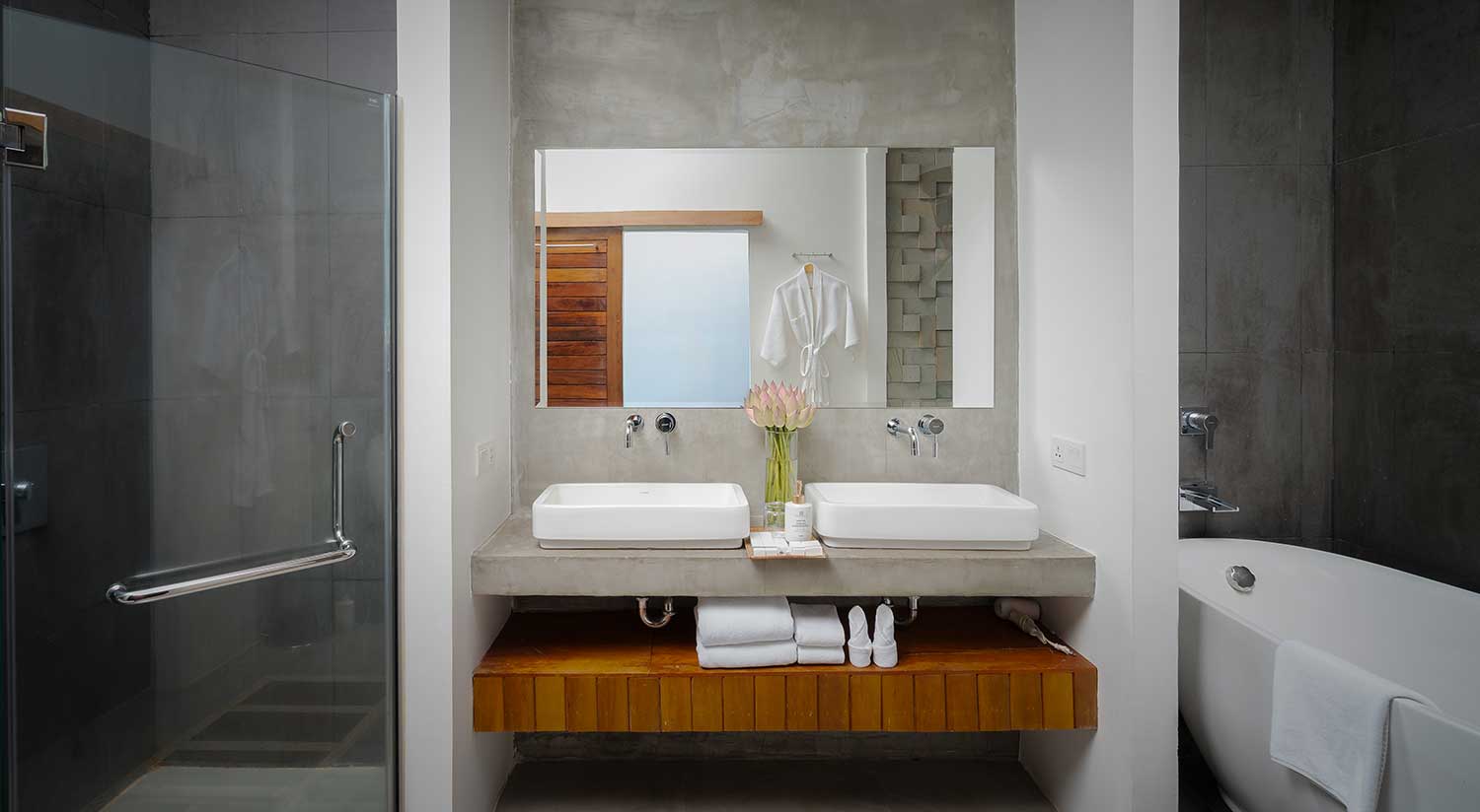 Modern en-suite bathroom with a double vanity and minimalist wooden storage.
